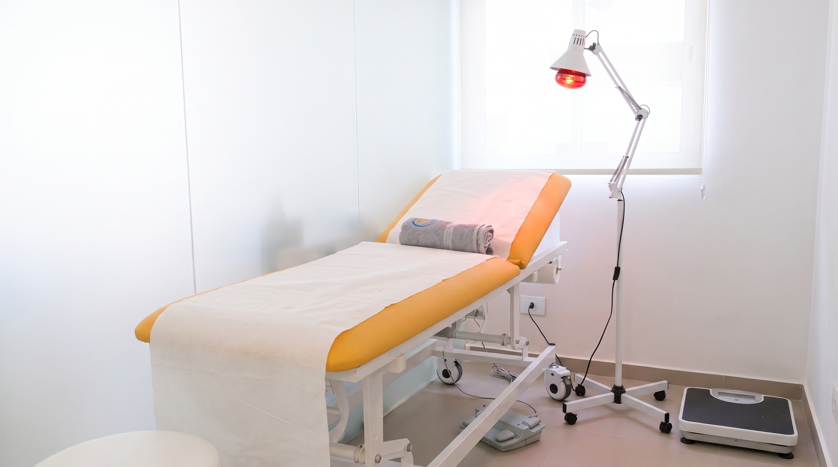 A rolled HealthSphere towel resting on the treatment bed